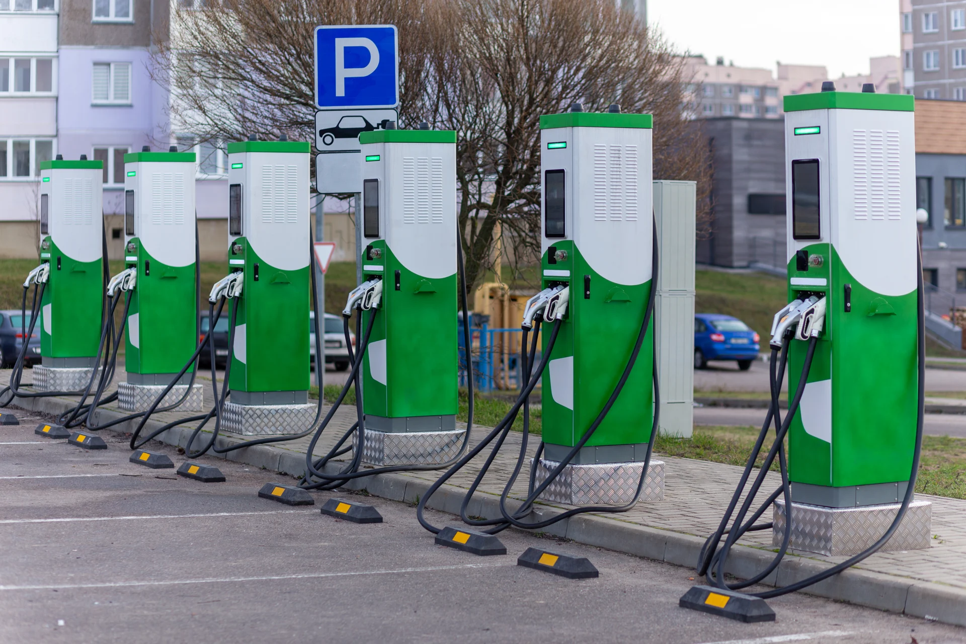 Mehrere Schnellladestationen mit Ladekabeln an einem Parkplatz